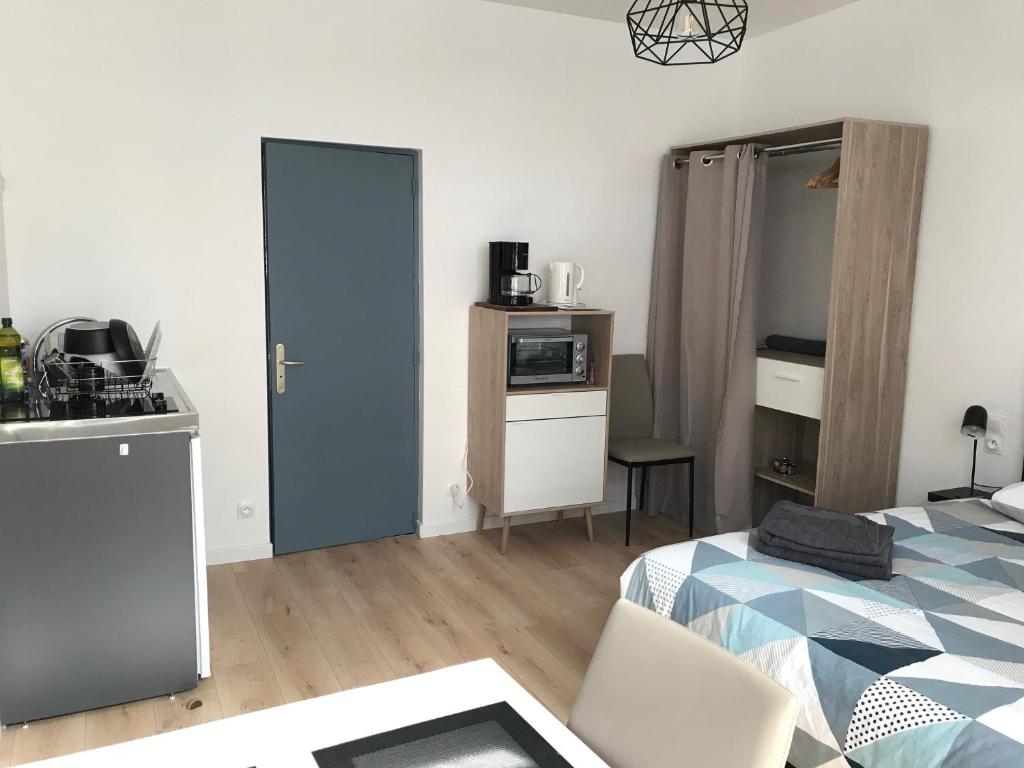 una sala de estar con cama y cocina y una habitación con cocina en Appartements du Vally - Guingamp, en Guingamp