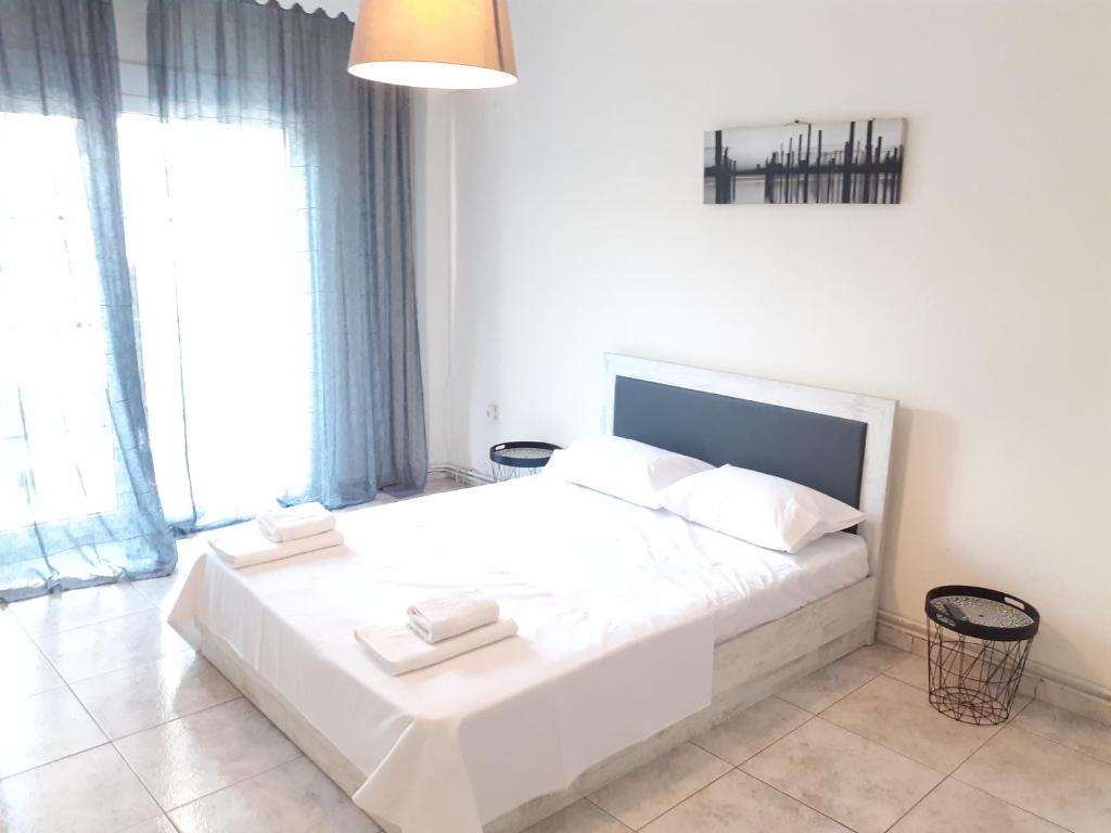 sypialnia z białym łóżkiem i 2 ręcznikami w obiekcie Asteris appartment w mieście Termi