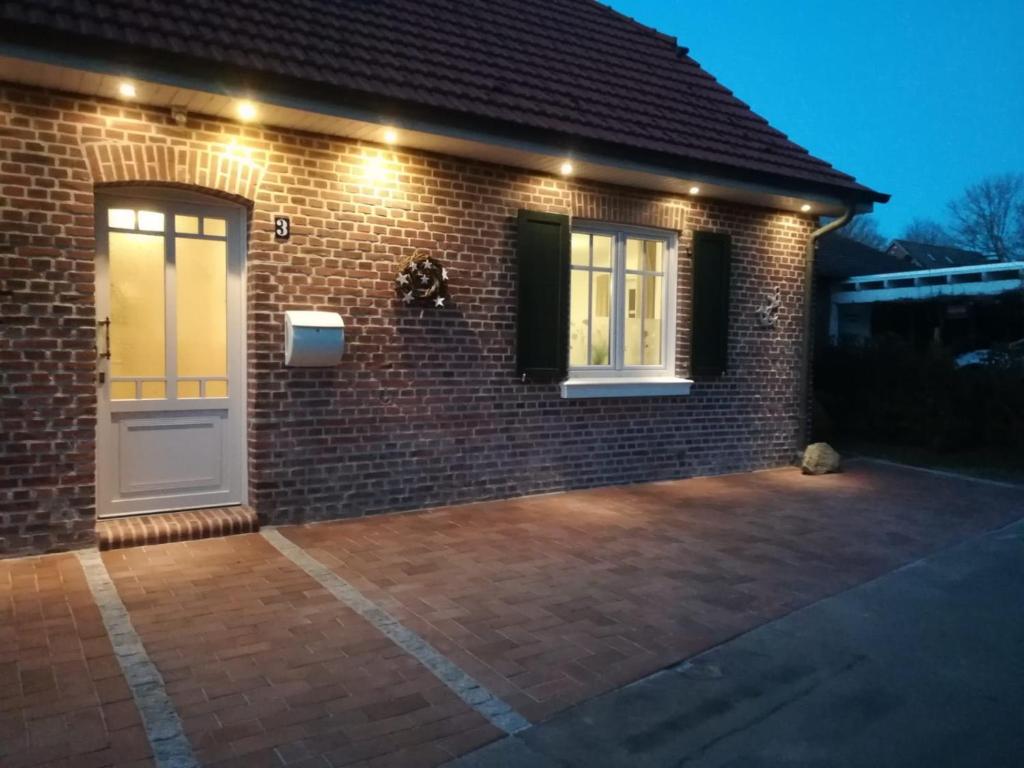 a brick house with a front door with lights at Fietes Ankerplatz in Wangerland