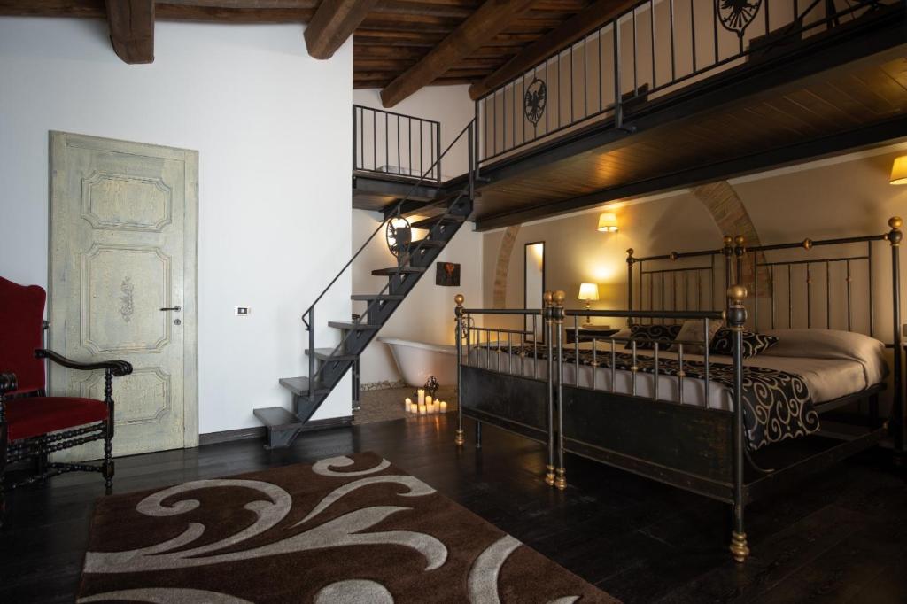 a bedroom with a large bed and a staircase at Borgo San Faustino Country Relais and Spa in Morrano