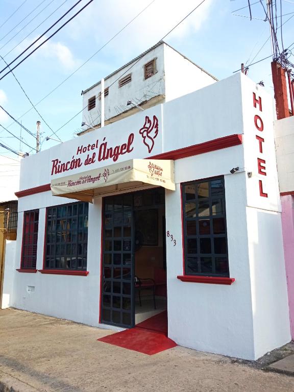 a white building with a sign that reads first trinity beamed at Rincón del Ángel in Villahermosa