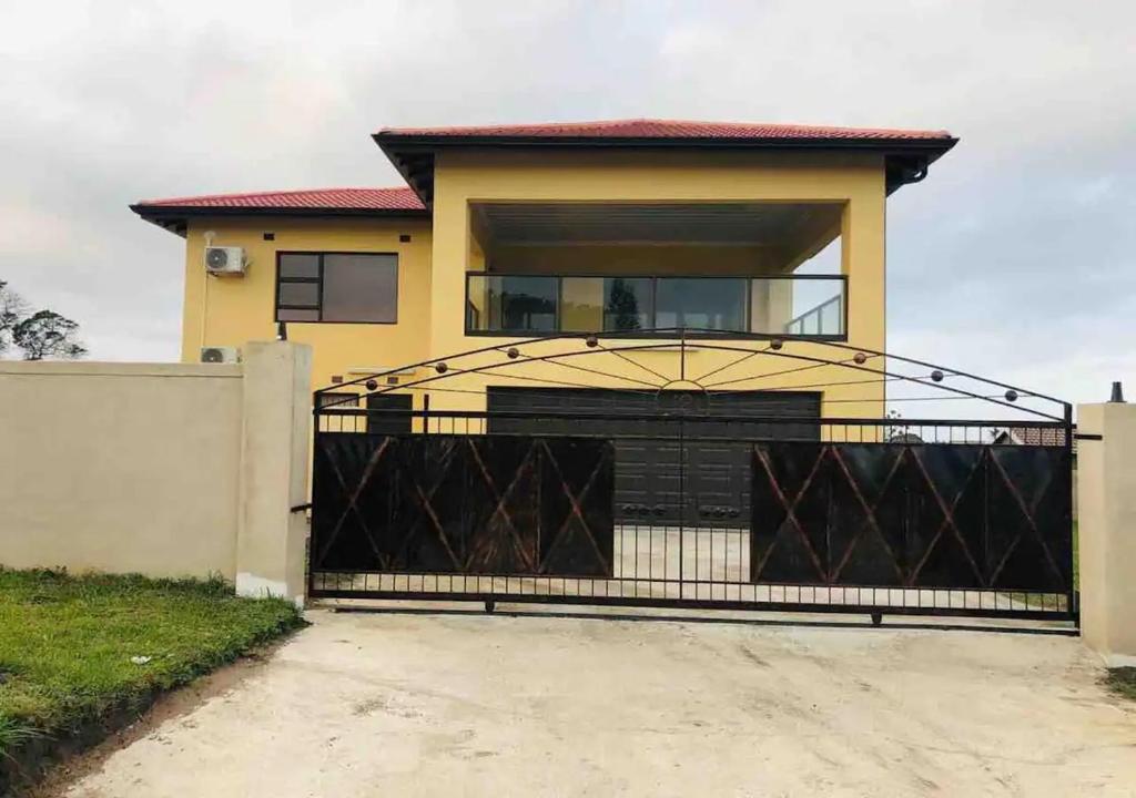 uma casa com um portão preto e uma entrada em Langelihle- Margate Accommodation em Margate