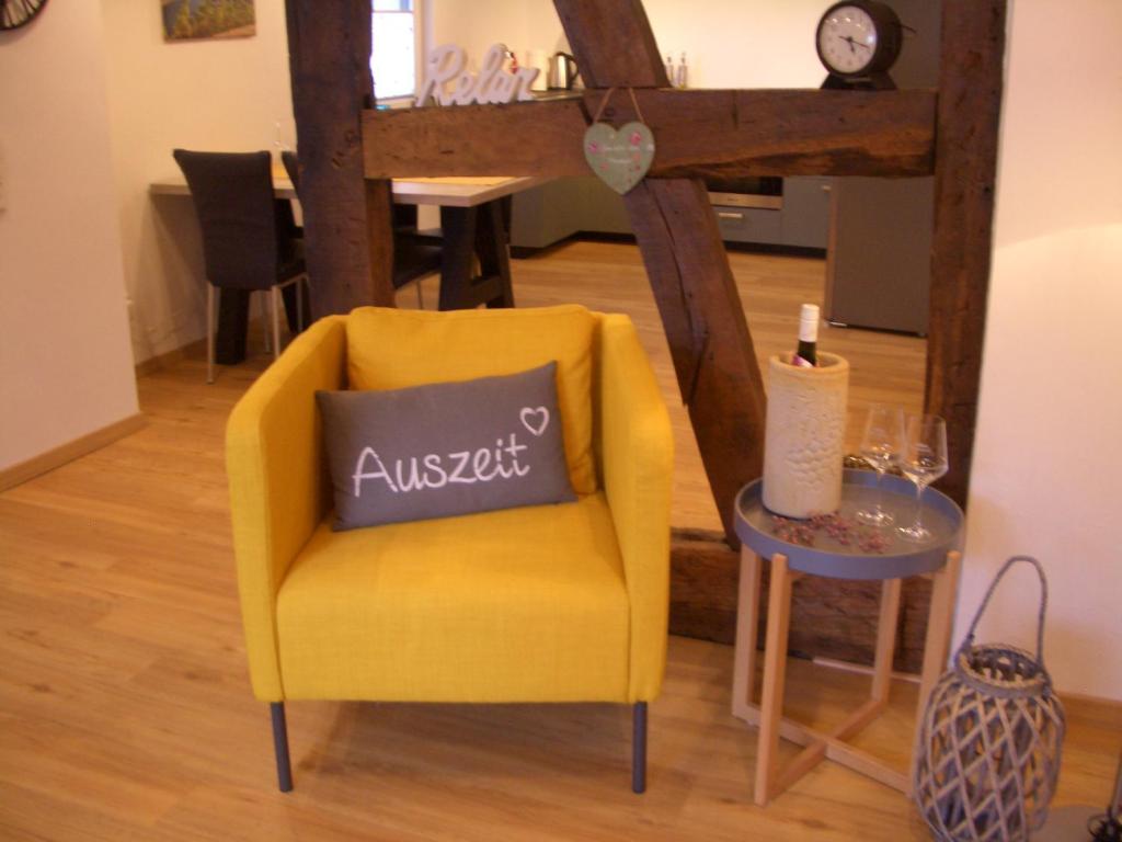 a yellow chair with a pillow on it next to a table at Ferienwohnung RheinSpaziert in Dellhofen