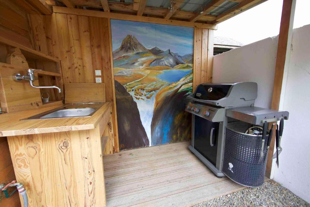 a kitchen with a grill and a painting on the wall at Le VISCOS à AGOS-VIDALOS in Agos-Vidalos
