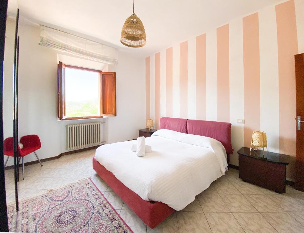 ルッカにあるCuore di Nozzano Castelloのベッドルーム1室(大型ベッド1台、赤い椅子付)