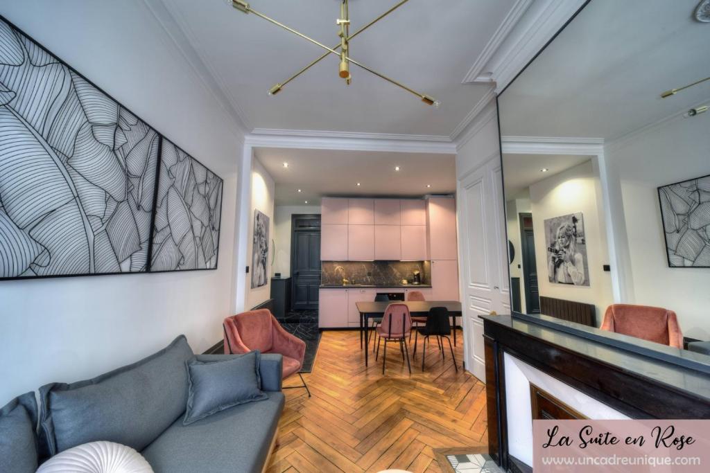 een woonkamer met een bank en een open haard bij La Suite en Rose - Spa - Brotteaux in Lyon
