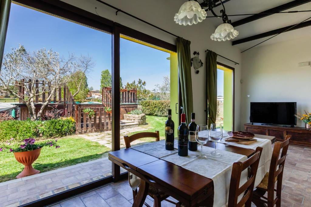 uma sala de jantar com uma mesa com garrafas de vinho em La Casina di Campagna em Foiano della Chiana