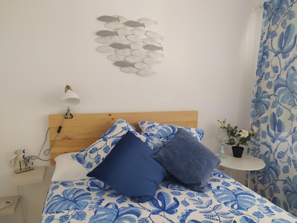 een slaapkamer met een bed met blauwe en witte kussens bij La Motilla in Barbate