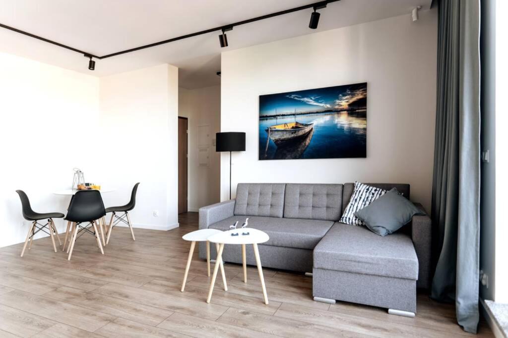 a living room with a couch and a table and chairs at Apartament BlueBay in Puck