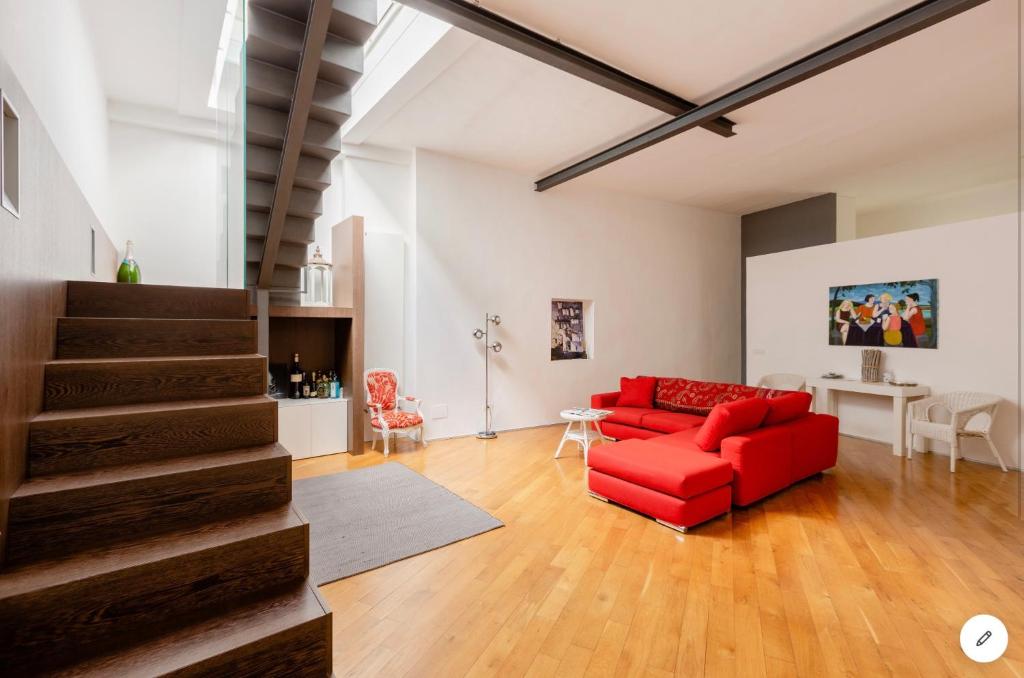 a living room with a red couch and a staircase at Bijoux Luxury Apartment in Old Town in Bari