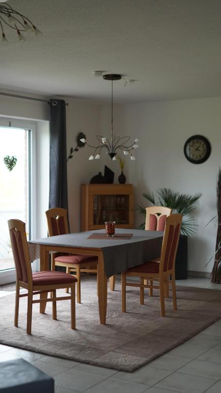 einen Esstisch und Stühle im Wohnzimmer in der Unterkunft Ferienwohnung Kalltalblick in Simmerath