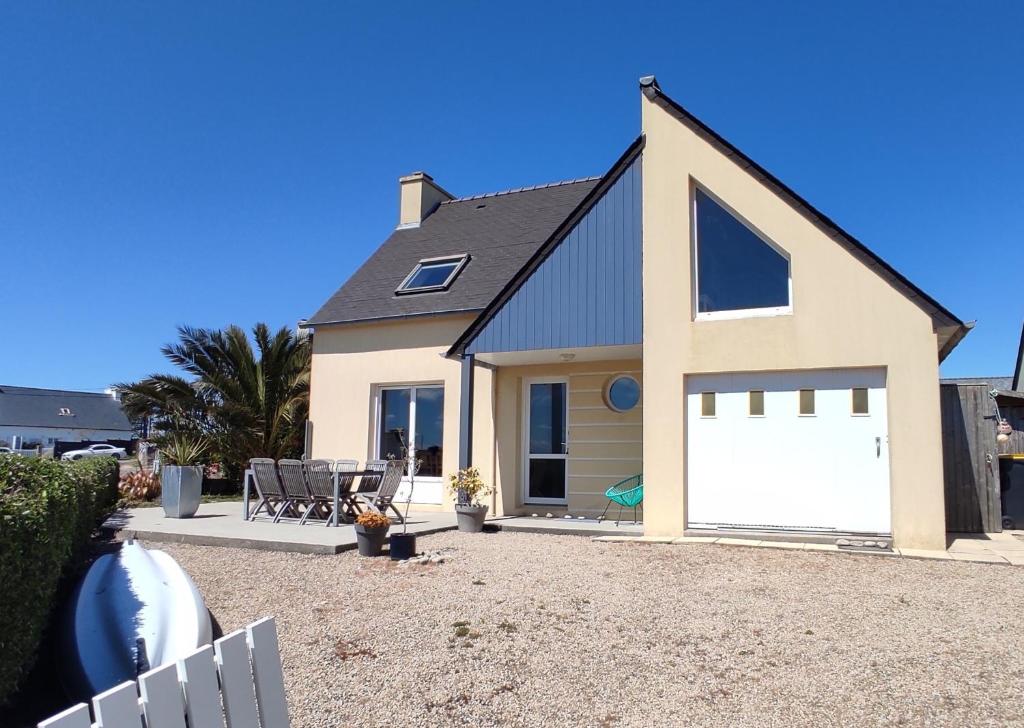 a detached house with a white garage door at Maison de vacances bord de mer Sibiril Moguériec finistère la villa Léonie in Sibiril