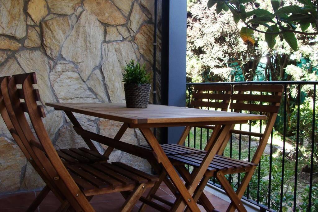 ein Holztisch und ein Stuhl mit einer Topfpflanze auf einer Terrasse in der Unterkunft Apartamento al lado de la playa con parking y jardín in Platja  d'Aro