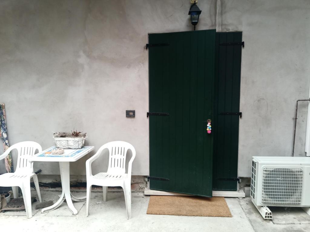 a green door sitting next to a table and chairs at casa nonni in Mantova