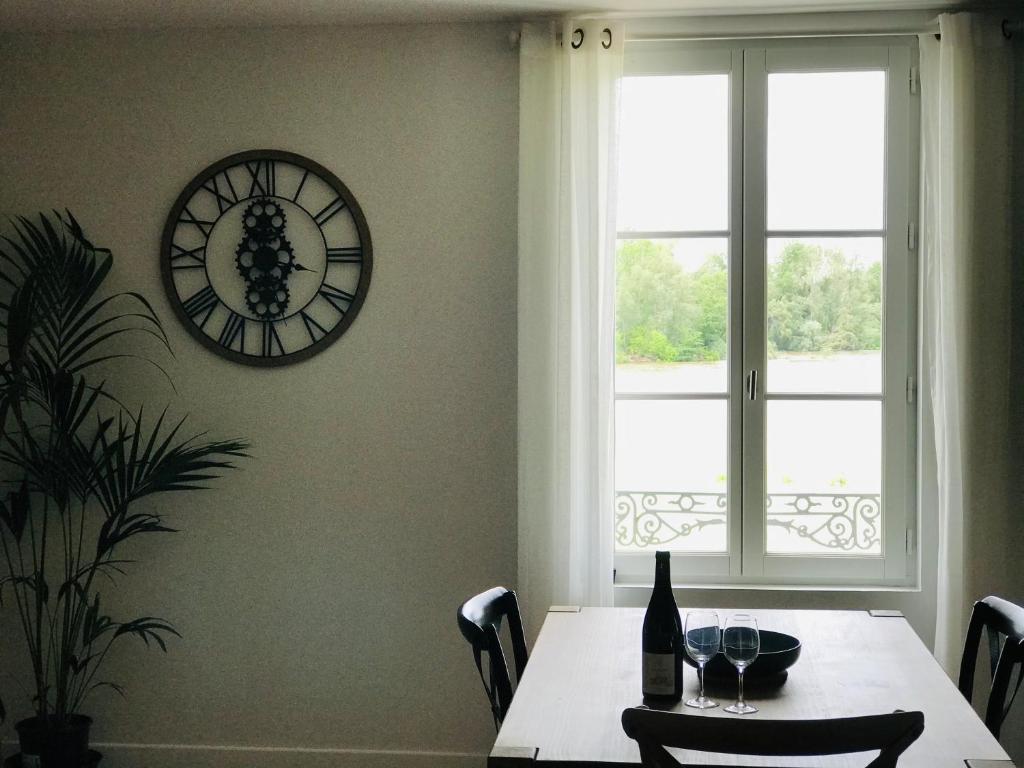 a dining room with a table and a clock on the wall at Au pied du Chateau de Chaumont sur Loire in Chaumont-sur-Loire
