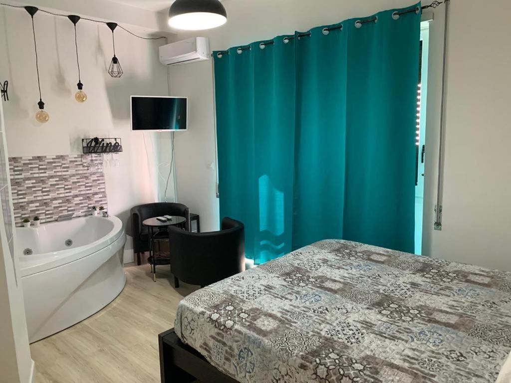 La salle de bains est pourvue d'une baignoire et d'un rideau de douche bleu. dans l'établissement Luxury Suite Aurora, à Formia