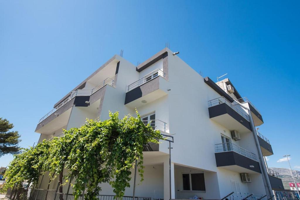 ein weißes Gebäude mit einem Baum davor in der Unterkunft Apartments Dzeki in Split