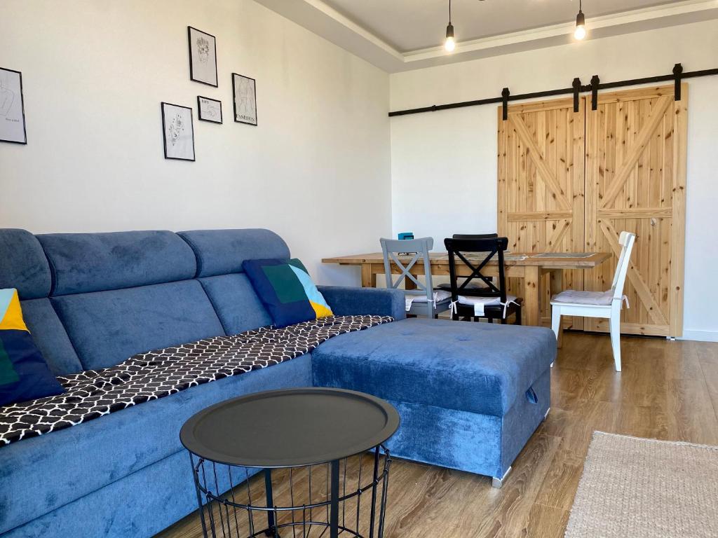 a living room with a blue couch and a table at SunRise Apartament in Lublin