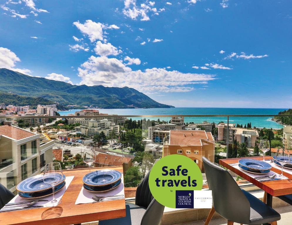 - un balcon doté d'une table et d'un panneau indiquant des voyages sûrs dans l'établissement Hotel Lusso Mare by Aycon, à Budva