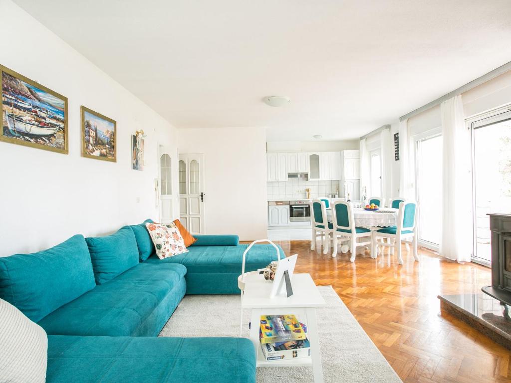 un soggiorno con divano blu e tavolo di Apartments Lovrić a Trogir