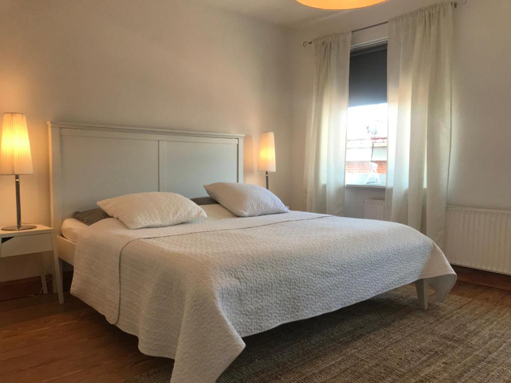 1 dormitorio con 1 cama con 2 almohadas y ventana en Wohnung Bel Etage im historischen Amtshaus en Fehmarn