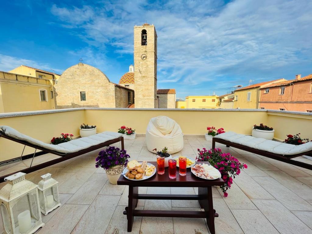 einen Balkon mit einem Tisch mit Essen drauf in der Unterkunft La casa del pittore in Olbia