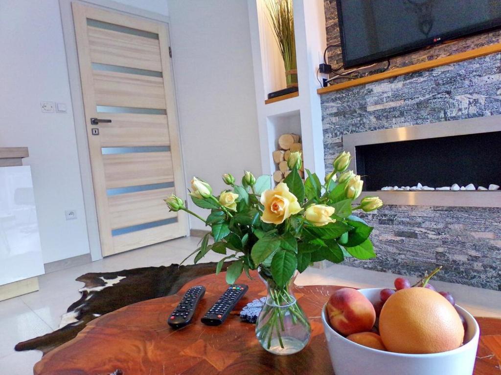 扎科帕內的住宿－Apartament Makalu，花瓶和水果放在桌子上