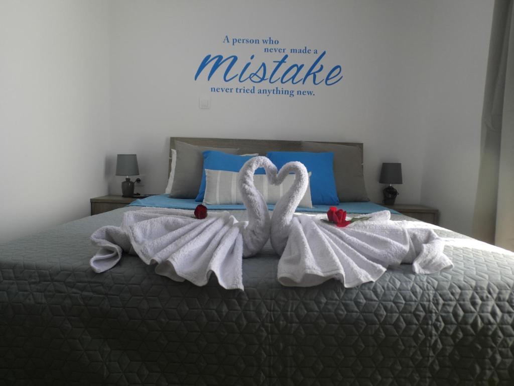 two towel swans are sitting on top of a bed at Armonia Apartment in Potos