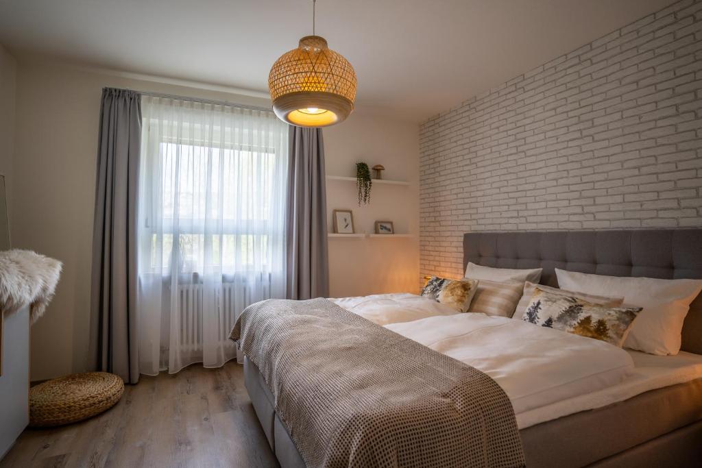 a bedroom with a large bed and a brick wall at Waldrausch Titisee in Titisee-Neustadt