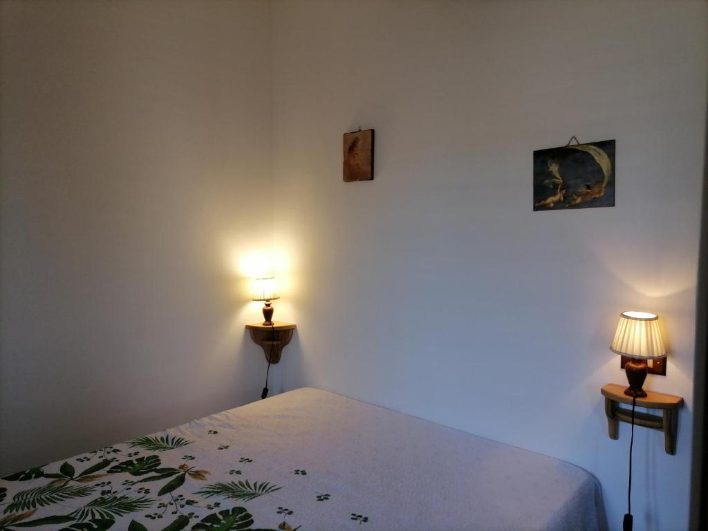ein Schlafzimmer mit einem Bett mit zwei Leuchten in der Unterkunft Casa Vacanze "Villa Angelina" in Lipari