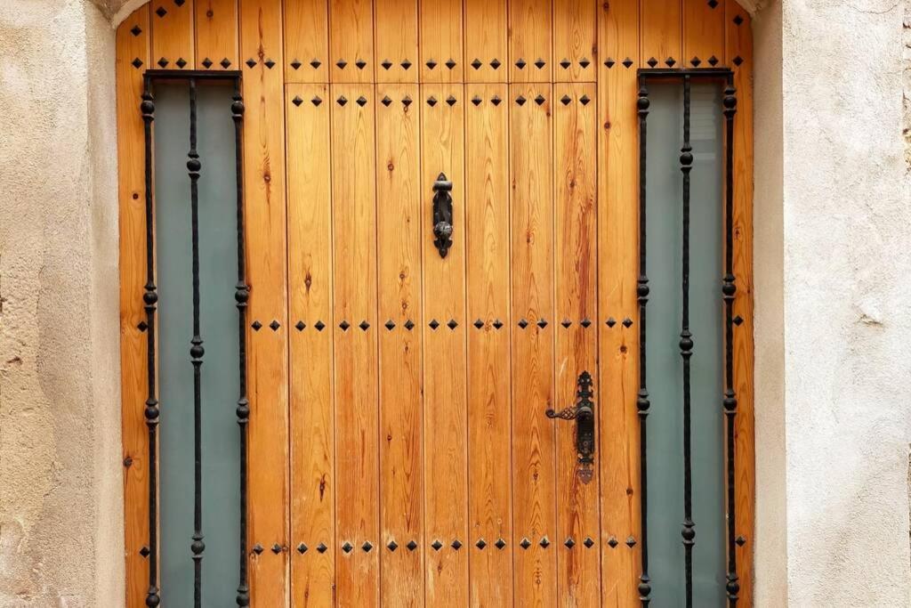 una puerta de madera con dos mangos en un edificio en Ca l'Andròmines, en Pinell de Bray