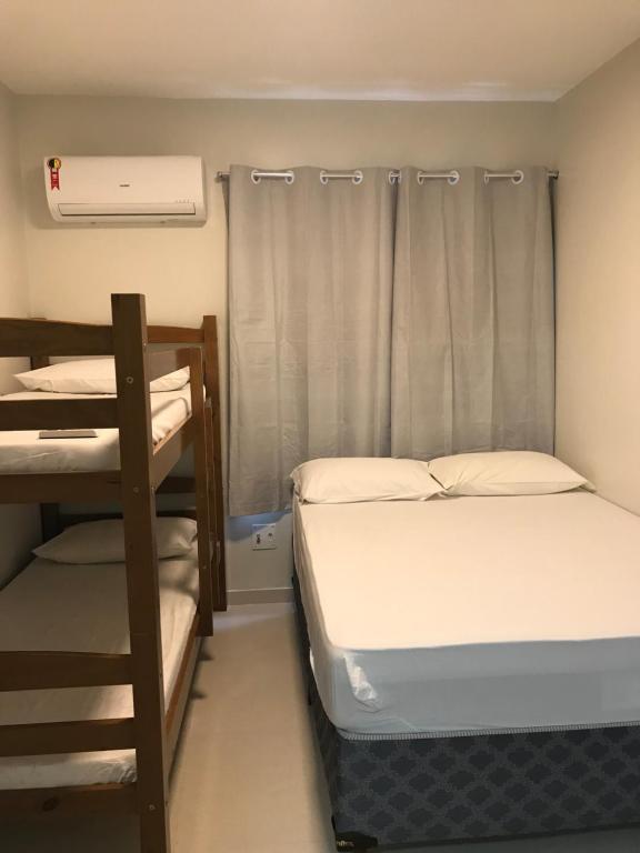 a bedroom with two bunk beds and a window at Kitnet na Boa Vista, Recife - 508 in Recife