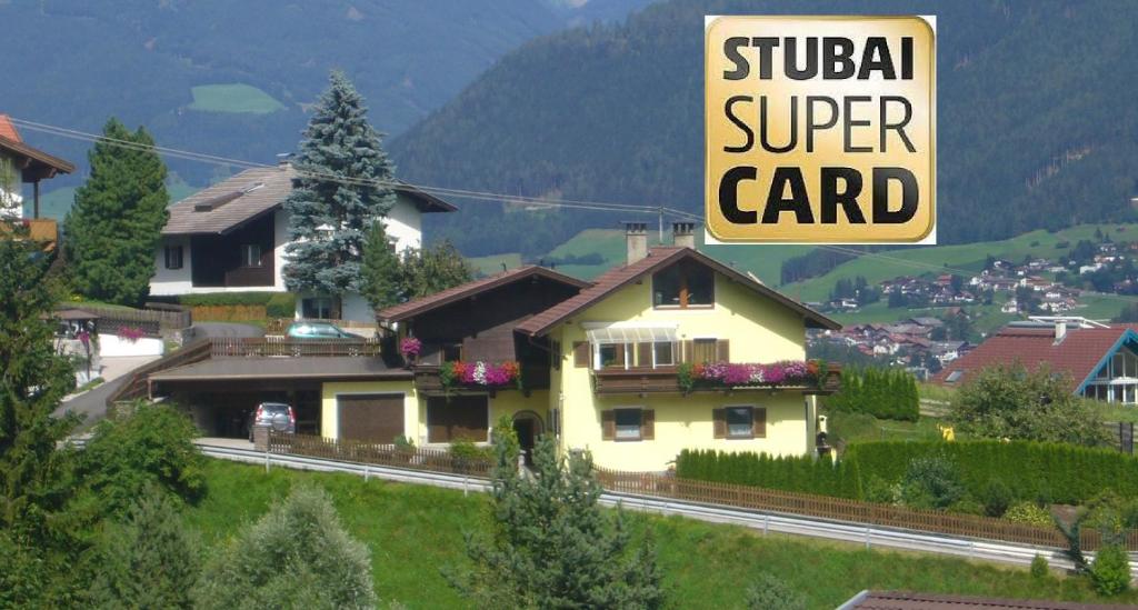 a yellow house with a sign that reads stupid super card at Appartements Gerhard in Telfes im Stubai