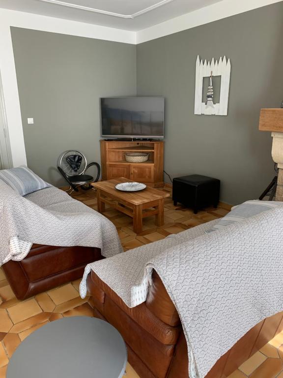 a living room with two beds and a flat screen tv at Appartement la corde a linge Gruissan village avec terrasses in Gruissan