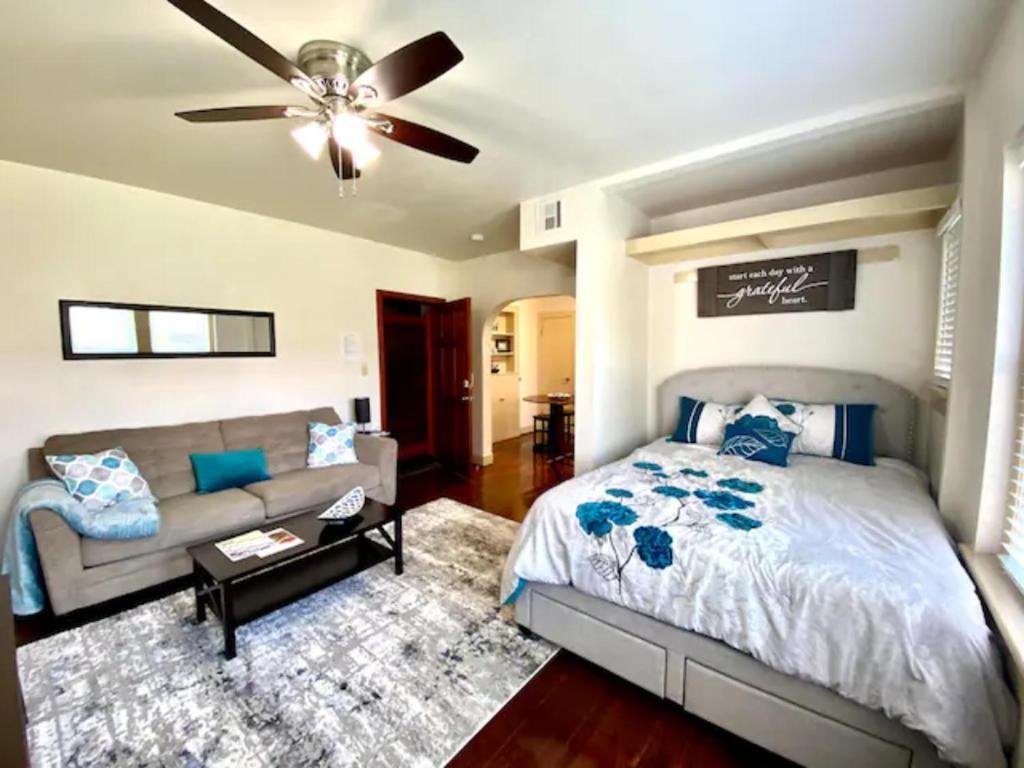 een slaapkamer met een bed, een bank en een plafondventilator bij Bright OKC Midtown Studio-Coolest neighborhood in Oklahoma City