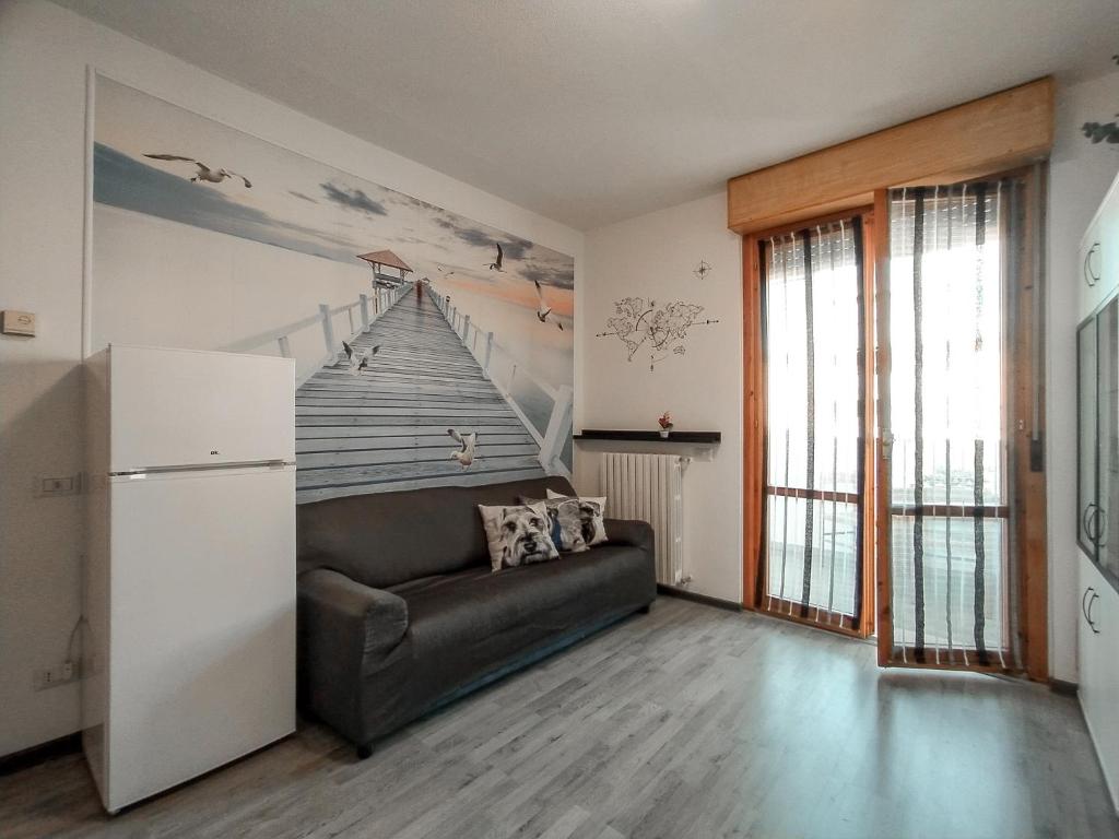 a living room with a couch and a stairs mural at Finestra sul mare in Lido di Fermo