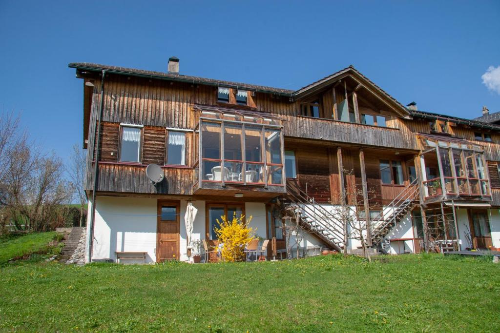 een groot houten huis op een grasheuvel bij Haus Klebern, Egg - im Zentrum des Bregenzerwaldes in Egg