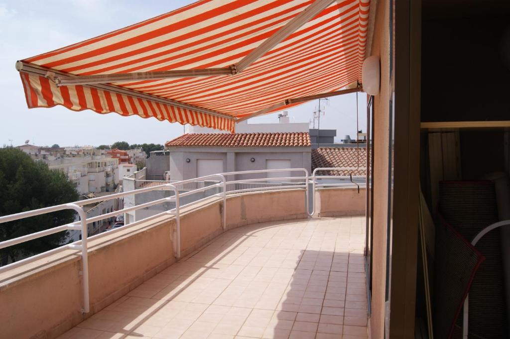a balcony with an orange umbrella on a building at Alcocebre Playa del Cargador in Alcossebre