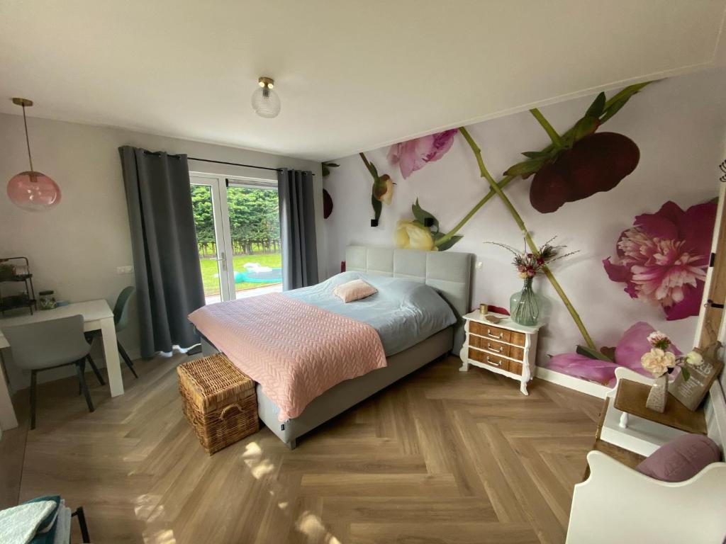 1 dormitorio con 1 cama y flores en la pared en Paauwze, en Rijnsburg