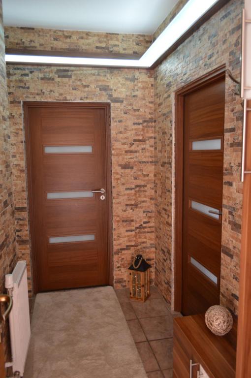 ハイドゥソボスローにあるAngéla Apartmanのレンガの壁の客室内の木製ドア2つ