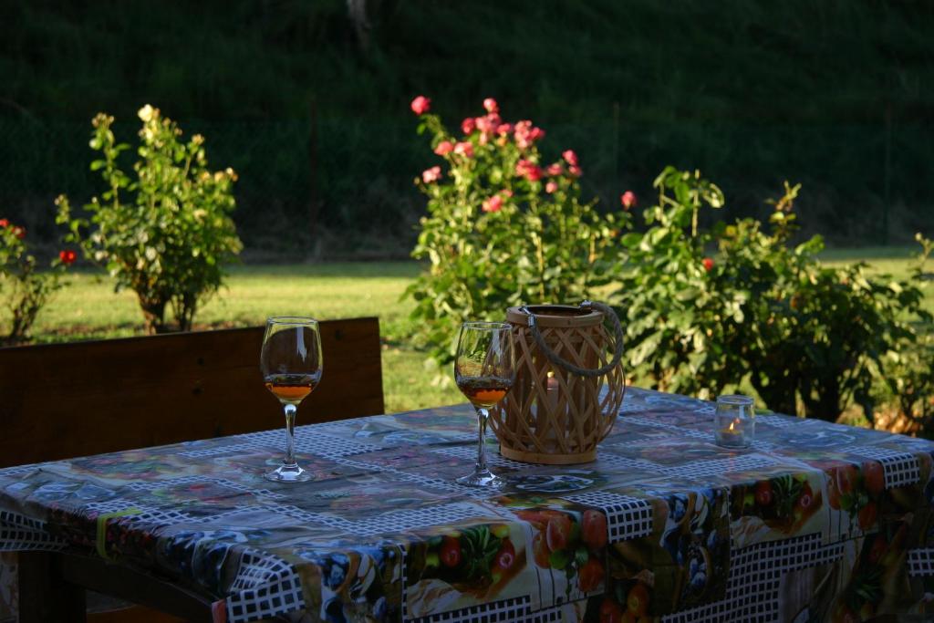 a table with two wine glasses and a vase on it at Villa Lilli 3 in Ferrara