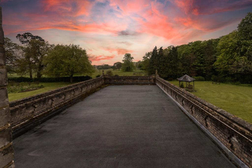 an empty bridge with a cloudy sky in the background at Broom Hall Country Hotel in Saham Toney