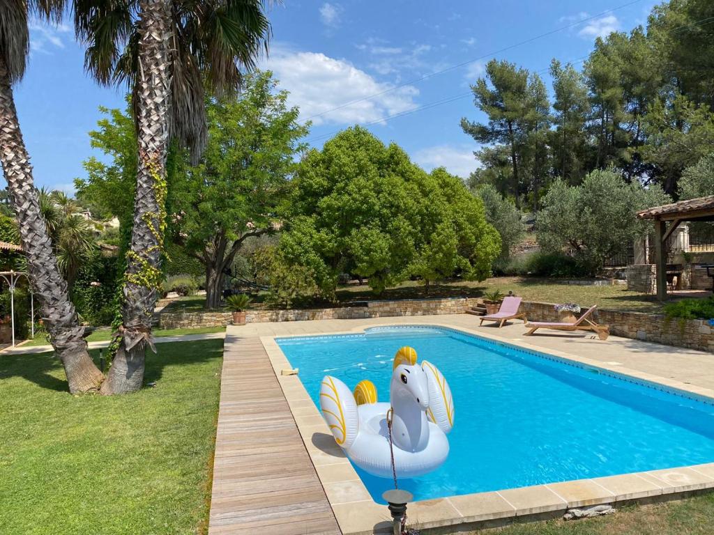 a swimming pool with a swan statue in a yard at Maison au Castellet in Le Castellet
