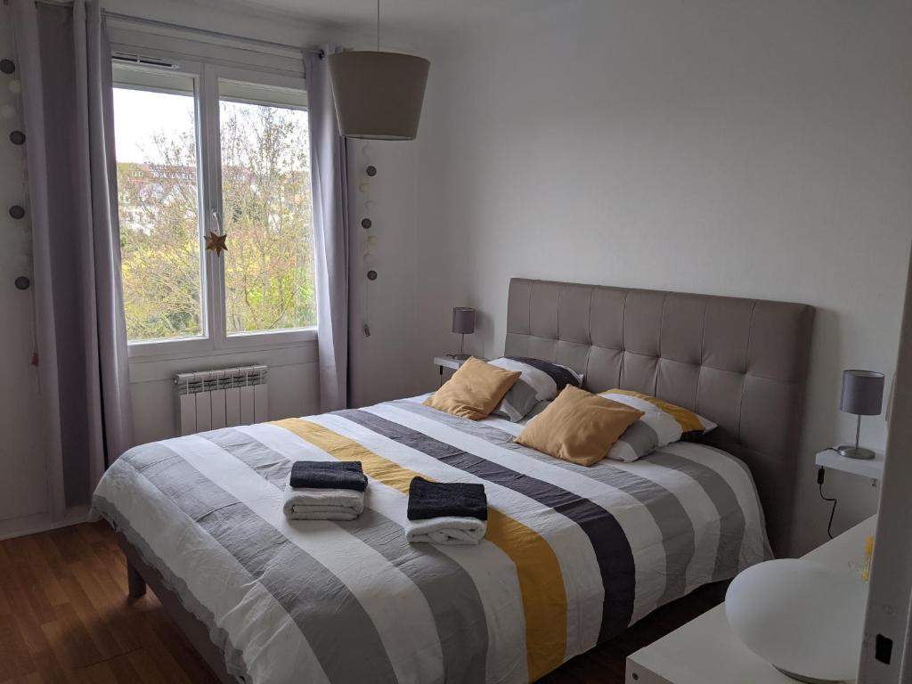 een slaapkamer met een groot bed en handdoeken bij DRINOU HOUSE in Boulogne-sur-Mer