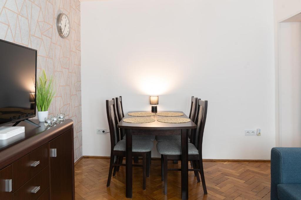 uma mesa de jantar com cadeiras e um candeeiro em Własne M-Studio CENTRUM parter em Konin
