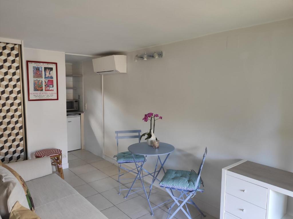 a living room with a table and chairs and a kitchen at La Glycine Tropézienne in Saint-Tropez