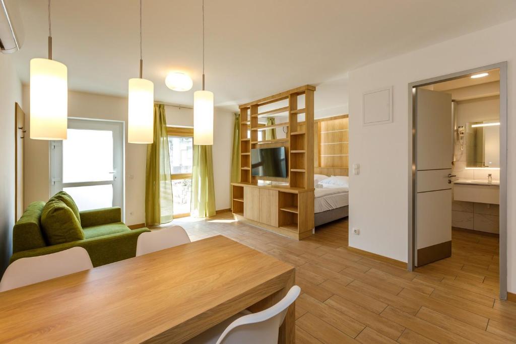 1 dormitorio y sala de estar con mesa de comedor. en La Bella Centrum Apartmanok Kék Zöld, en Hévíz
