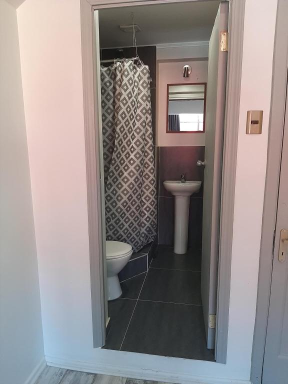 a bathroom with a toilet and a sink at Aji Hostel in Santiago
