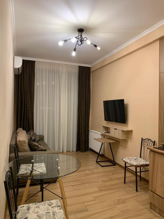a living room with a table and a television at Melikishvili str. apartment in Tbilisi City