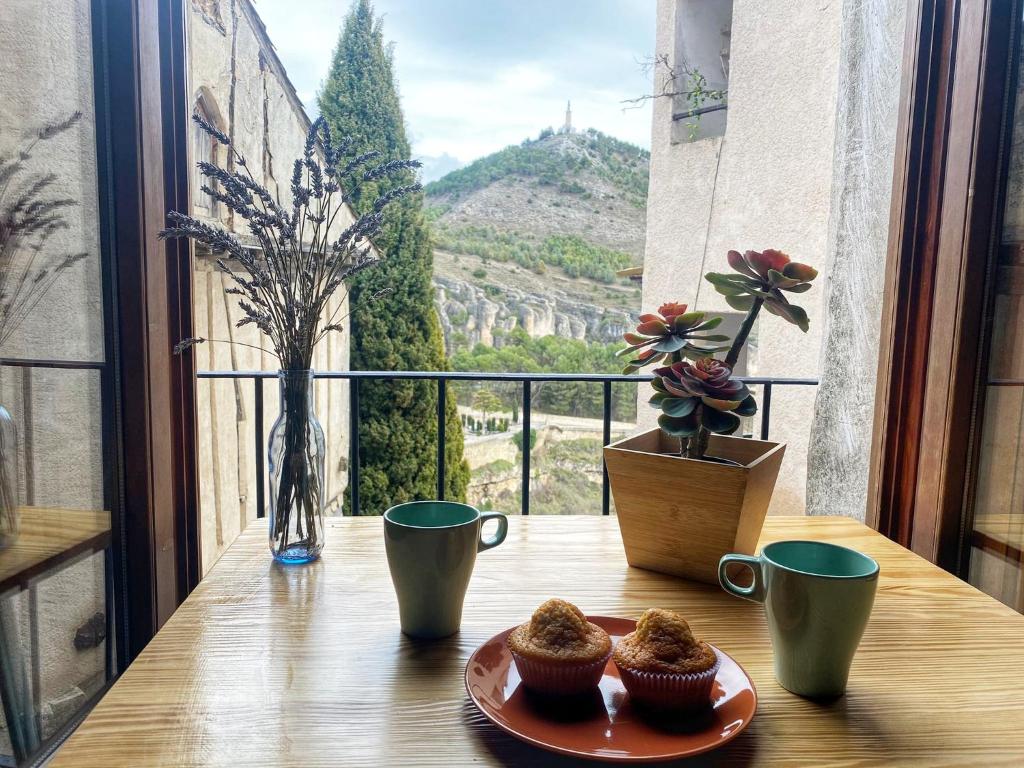 - une table avec deux petits gâteaux sur une table avec vue dans l'établissement APARTAMENTO LA PONDEROSA, à Cuenca